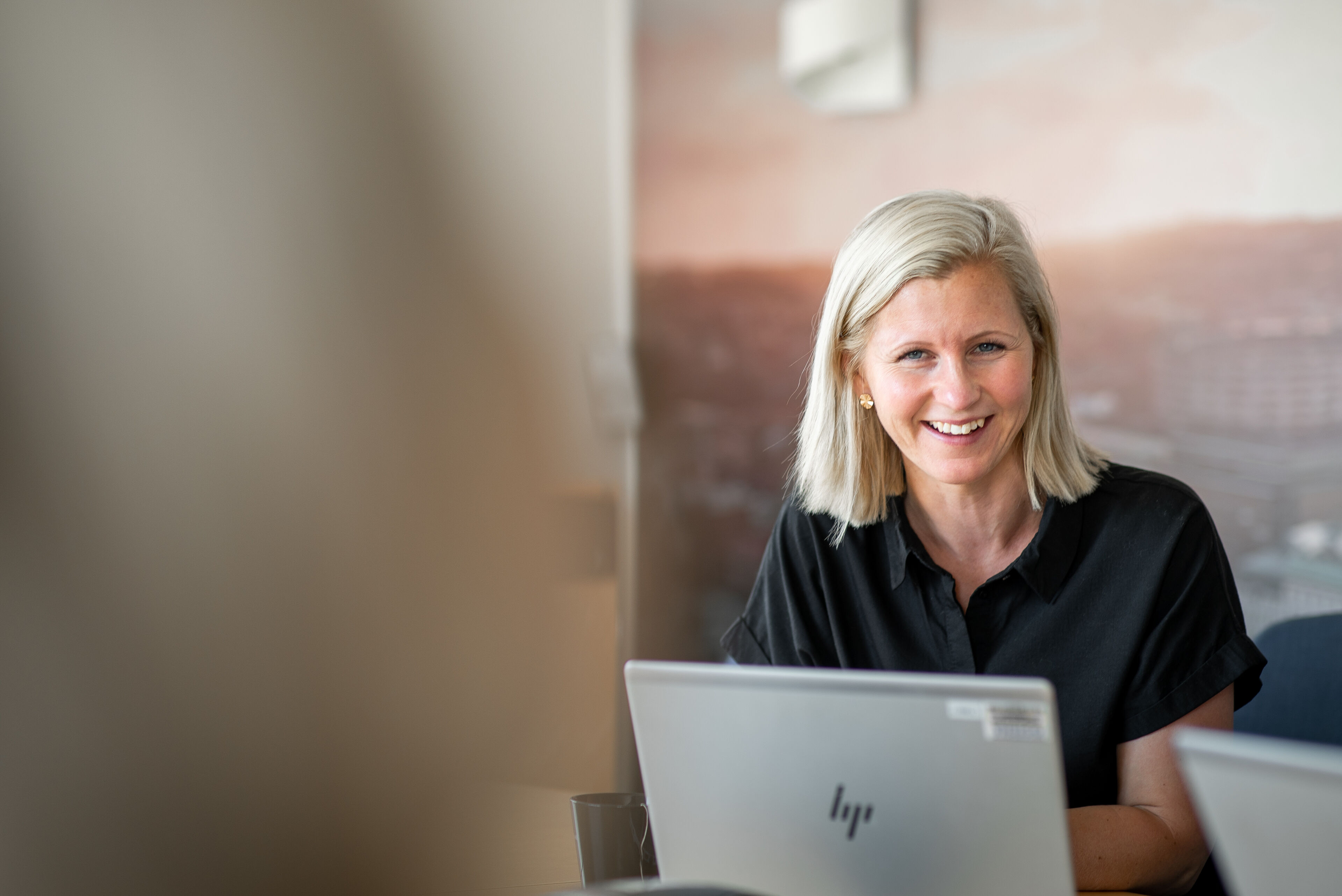 Blond kvinna framför en laptop